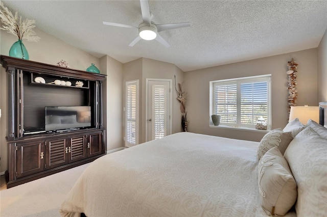 bedroom featuring lofted ceiling, a textured ceiling, ceiling fan, and carpet flooring