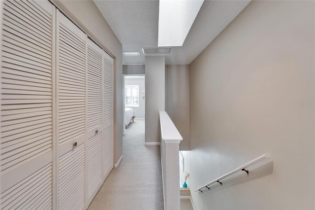 hallway featuring light carpet and a textured ceiling