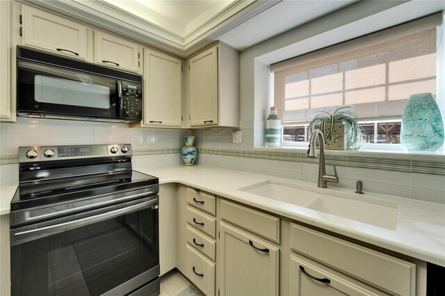 17960 Gulf Blvd Unit 103, Redington Shores, FL 33708 - kitchen with decorative backsplash, black microwave, light countertops, a sink, and electric stove