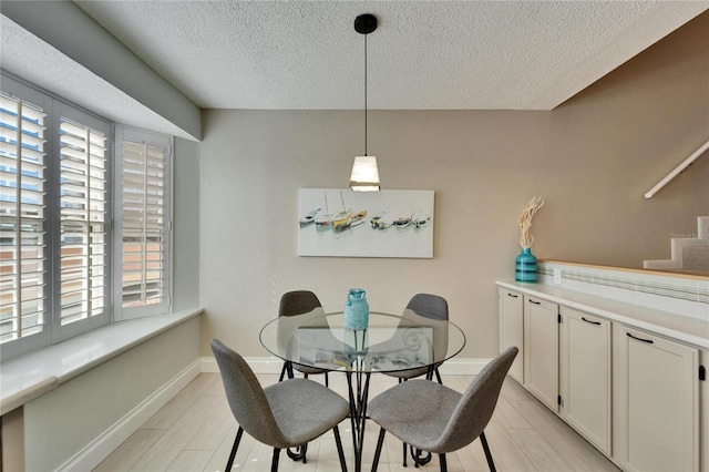 17960 Gulf Blvd Unit 103, Redington Shores, FL 33708 - dining space with light wood-style floors, baseboards, plenty of natural light, and a textured ceiling