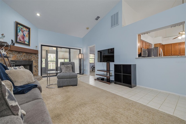 living room featuring ceiling fan, light colored carpet, a fireplace, and high vaulted ceiling