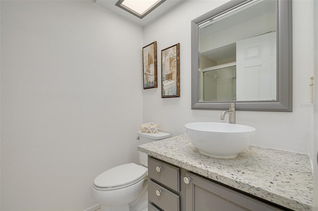 bathroom with vanity, toilet, and walk in shower