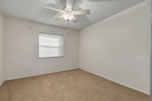 unfurnished room featuring ceiling fan, light colored carpet, and a textured ceiling