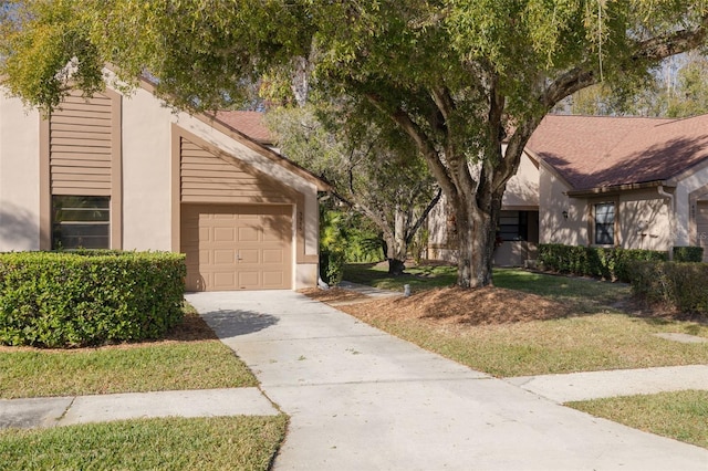 3985 Mermoor Dr, Palm Harbor, FL 34685 - view of front of property with concrete driveway, stucco siding, an attached garage, and a front yard