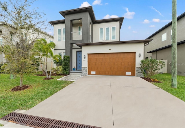 view of front of house featuring concrete driveway, a front lawn, and stucco siding