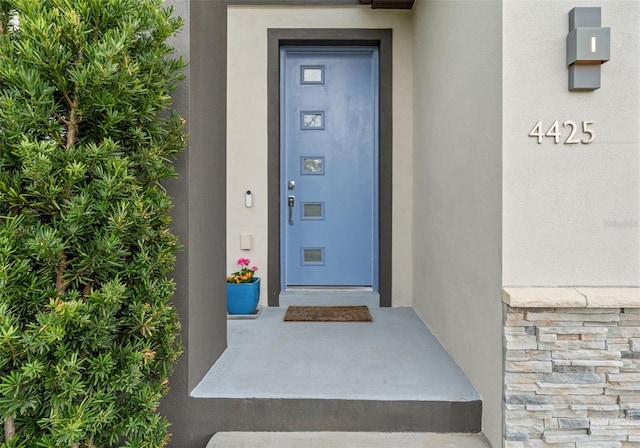 entrance to property featuring stucco siding