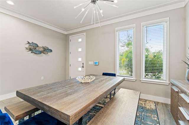 dining area featuring an inviting chandelier, wood finished floors, and baseboards