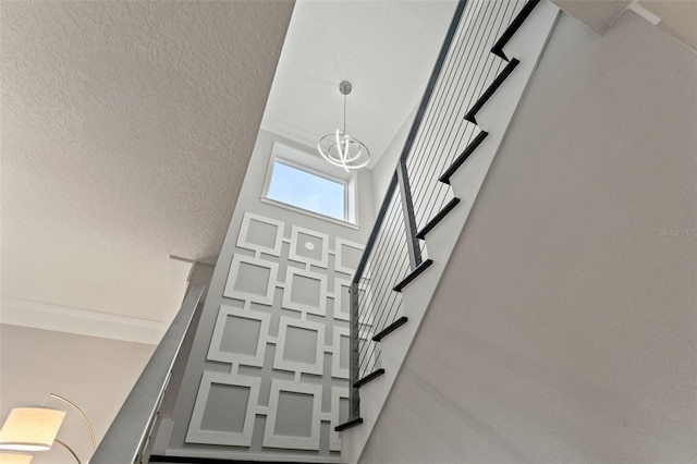 stairway featuring a high ceiling and an inviting chandelier