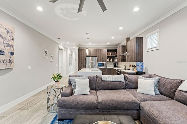 living area featuring baseboards, crown molding, and recessed lighting