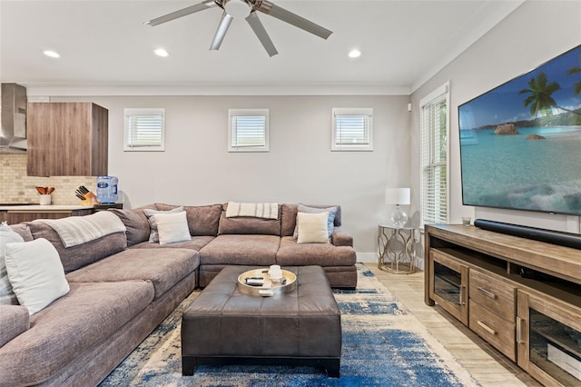 living room featuring light wood finished floors, baseboards, ornamental molding, and recessed lighting