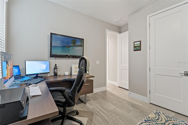 office space featuring wood finished floors, visible vents, and baseboards