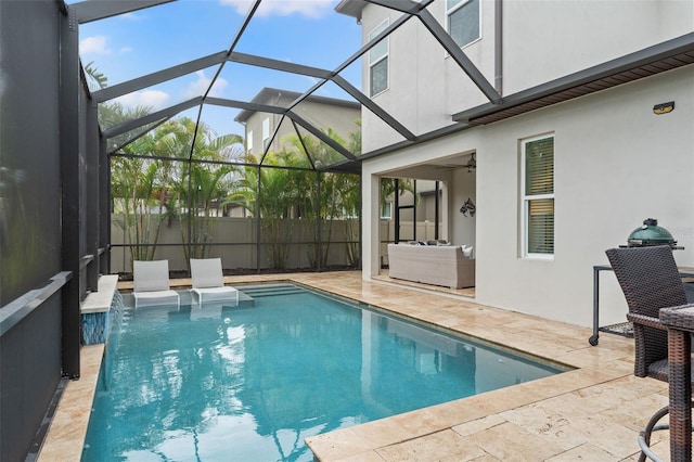 view of swimming pool with a patio, glass enclosure, fence, an outdoor living space, and a fenced in pool