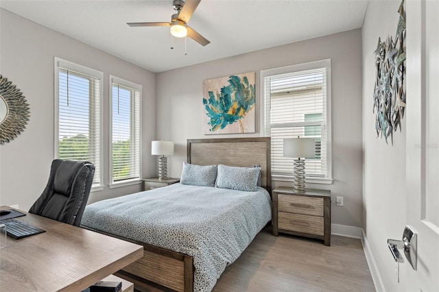 bedroom featuring a ceiling fan, baseboards, and light wood finished floors