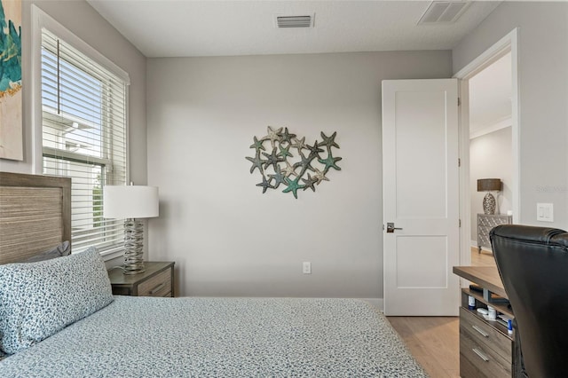 bedroom featuring light wood-style flooring and visible vents