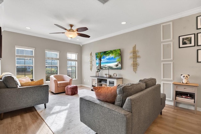 living room featuring ornamental molding, ceiling fan, and light wood-type flooring