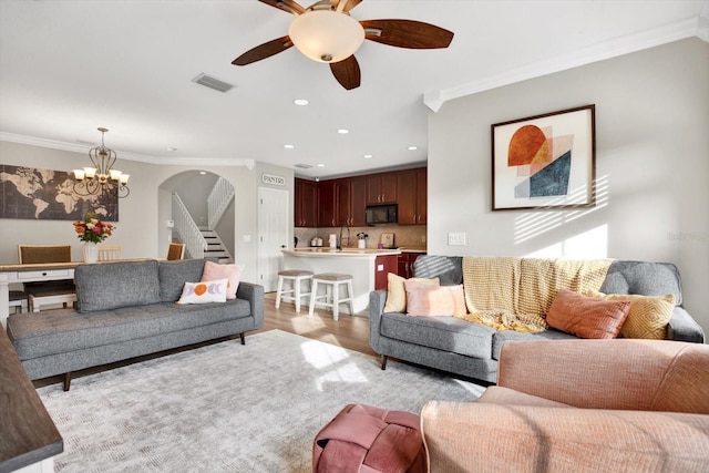 living room with ornamental molding, sink, ceiling fan with notable chandelier, and light hardwood / wood-style flooring