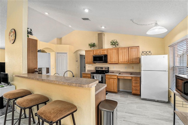 kitchen featuring stainless steel appliances, vaulted ceiling, a breakfast bar, and kitchen peninsula