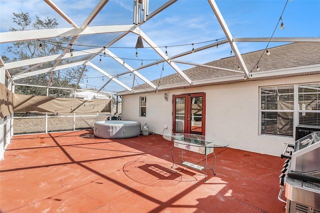 view of patio with a hot tub and a lanai