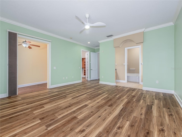 unfurnished bedroom with hardwood / wood-style floors, ensuite bath, ornamental molding, and ceiling fan