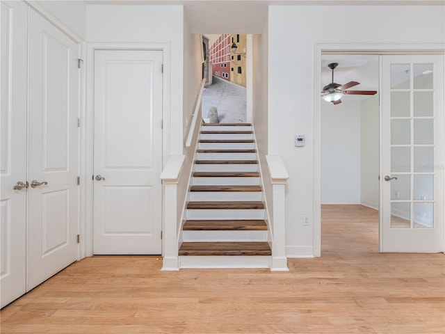 staircase featuring hardwood / wood-style flooring and ceiling fan