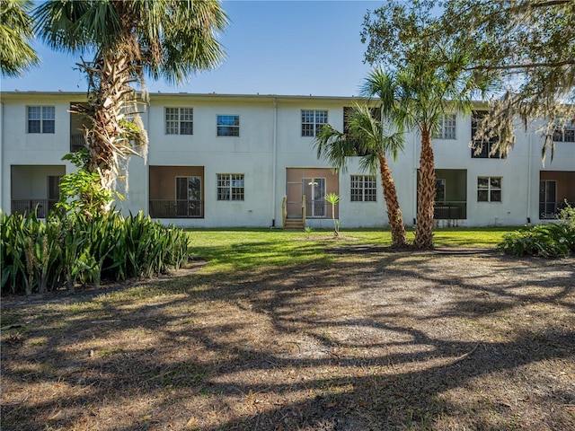 rear view of property featuring a lawn