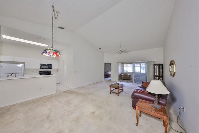 carpeted living room with high vaulted ceiling and ceiling fan