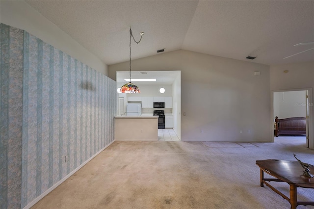 unfurnished living room with light carpet, vaulted ceiling, and a textured ceiling