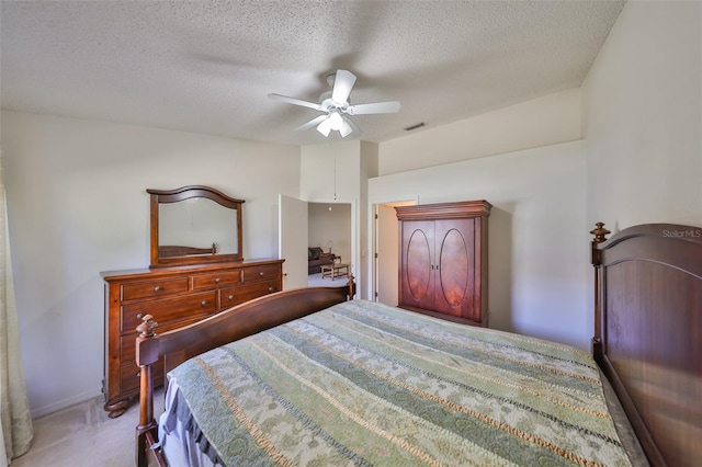 carpeted bedroom featuring ceiling fan and a textured ceiling