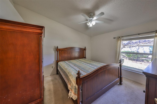 bedroom with ceiling fan, lofted ceiling, light carpet, and a textured ceiling