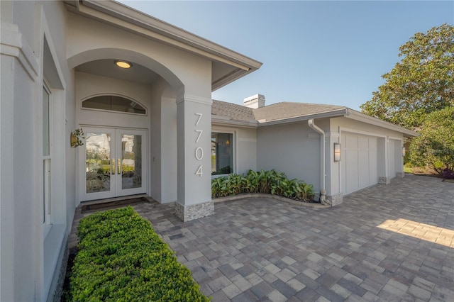 property entrance with a garage and french doors