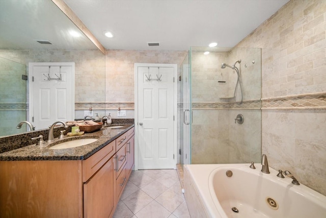 bathroom with independent shower and bath, vanity, tile patterned flooring, and tile walls