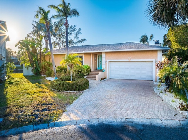 ranch-style house with a garage and a front yard