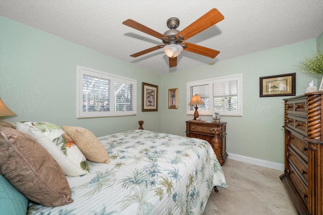 bedroom featuring multiple windows, ceiling fan, and a textured ceiling