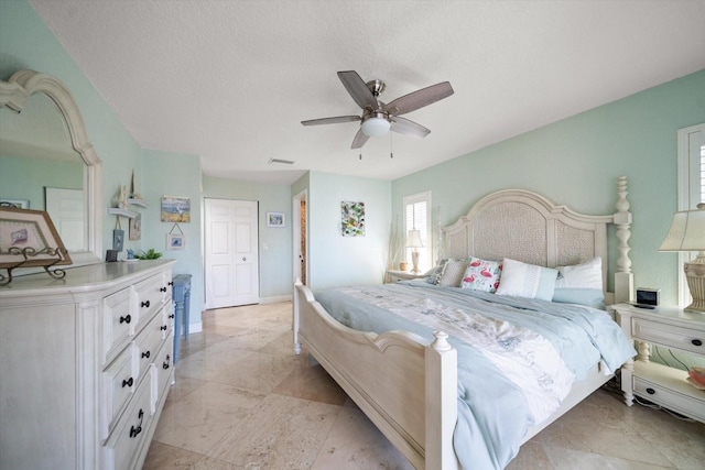 bedroom with ceiling fan and a textured ceiling