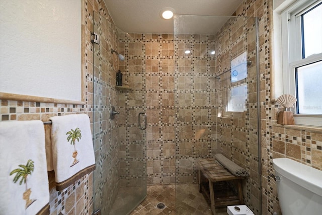 bathroom with walk in shower, tile walls, and toilet