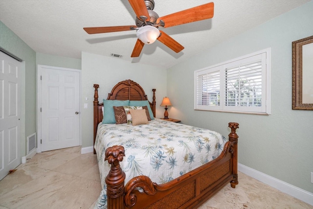 bedroom with a textured ceiling and ceiling fan