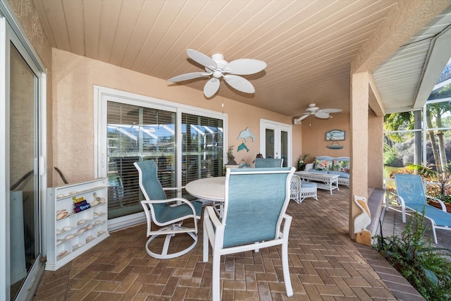 view of patio / terrace featuring wood ceiling, ceiling fan, plenty of natural light, and glass enclosure