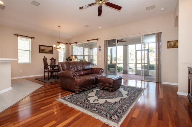 living room with dark hardwood / wood-style floors and ceiling fan with notable chandelier