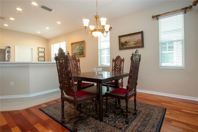 dining room with hardwood / wood-style flooring, plenty of natural light, and an inviting chandelier