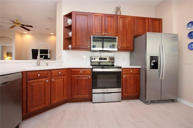 kitchen featuring sink, decorative backsplash, stainless steel appliances, and ceiling fan