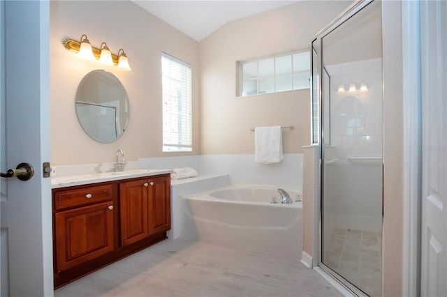 bathroom featuring vaulted ceiling, shower with separate bathtub, and vanity