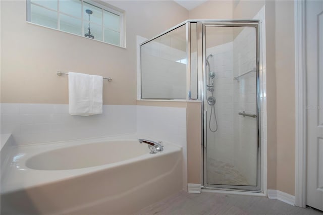 bathroom featuring shower with separate bathtub