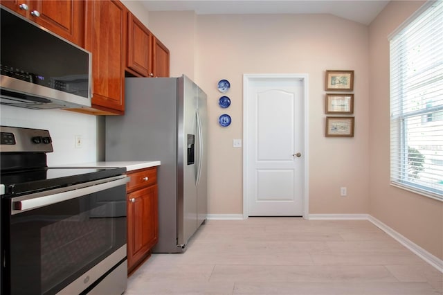 kitchen with lofted ceiling, light hardwood / wood-style floors, and appliances with stainless steel finishes