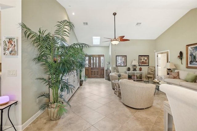 living room featuring light tile patterned floors, a skylight, high vaulted ceiling, and ceiling fan