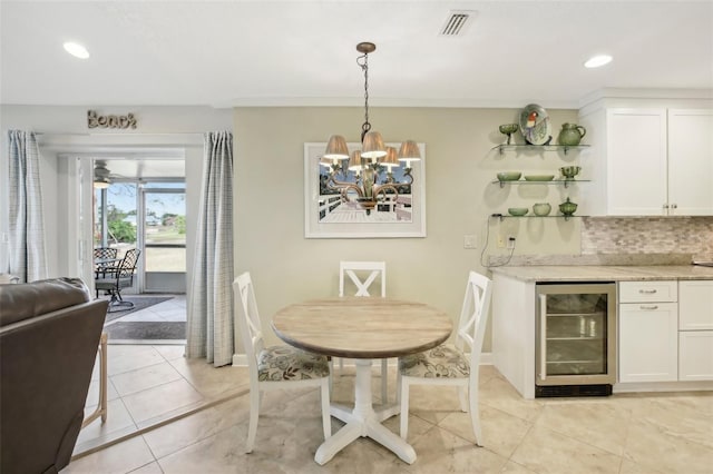 tiled dining room with beverage cooler and a chandelier