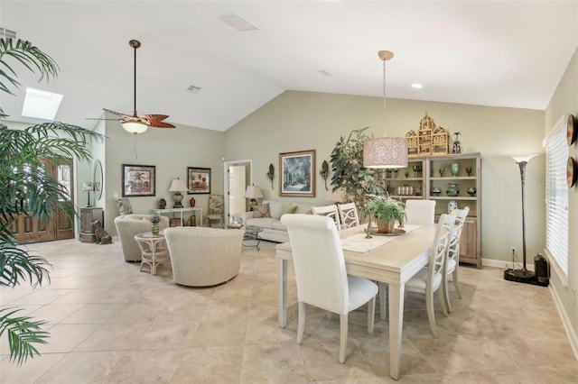 dining room with ceiling fan, a skylight, high vaulted ceiling, and light tile patterned floors