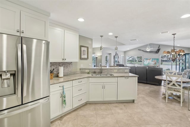 kitchen featuring white cabinetry, stainless steel refrigerator with ice dispenser, sink, and light stone counters