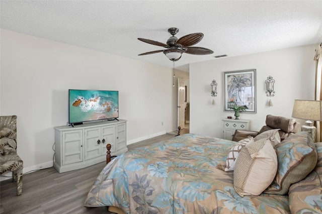 bedroom with ceiling fan, a textured ceiling, and light hardwood / wood-style floors