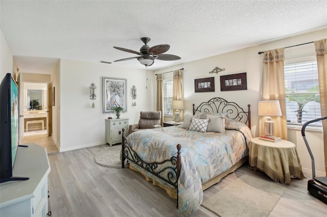 bedroom featuring ceiling fan, a textured ceiling, and light hardwood / wood-style floors