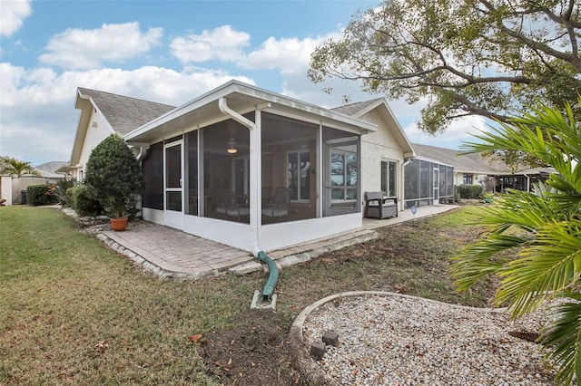 back of house with a yard and a sunroom